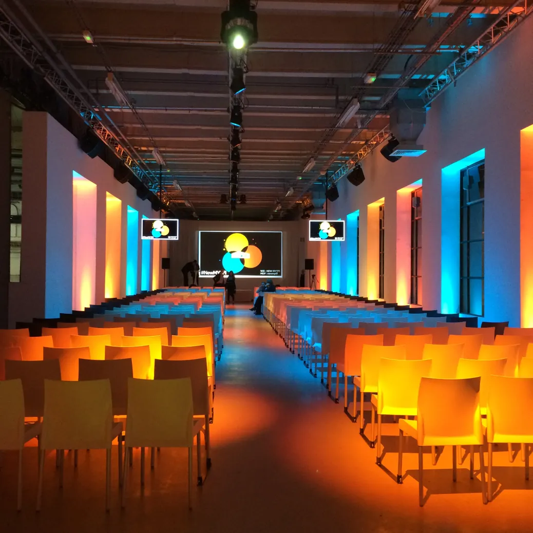 Photographie argentique en grain visible d'une salle de spectacle vide baignée dans une lumière orangée et bleue, ambiance dramatique de fin de séance.